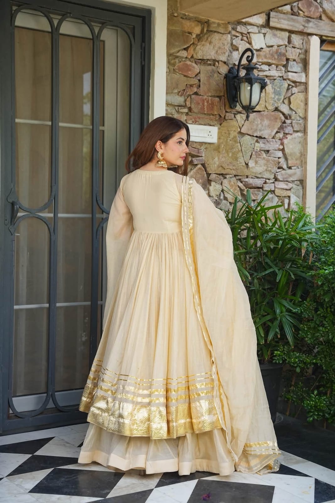 Model wearing an ivory and gold embroidered anarkali from the Dhanya Lifestyle atelier